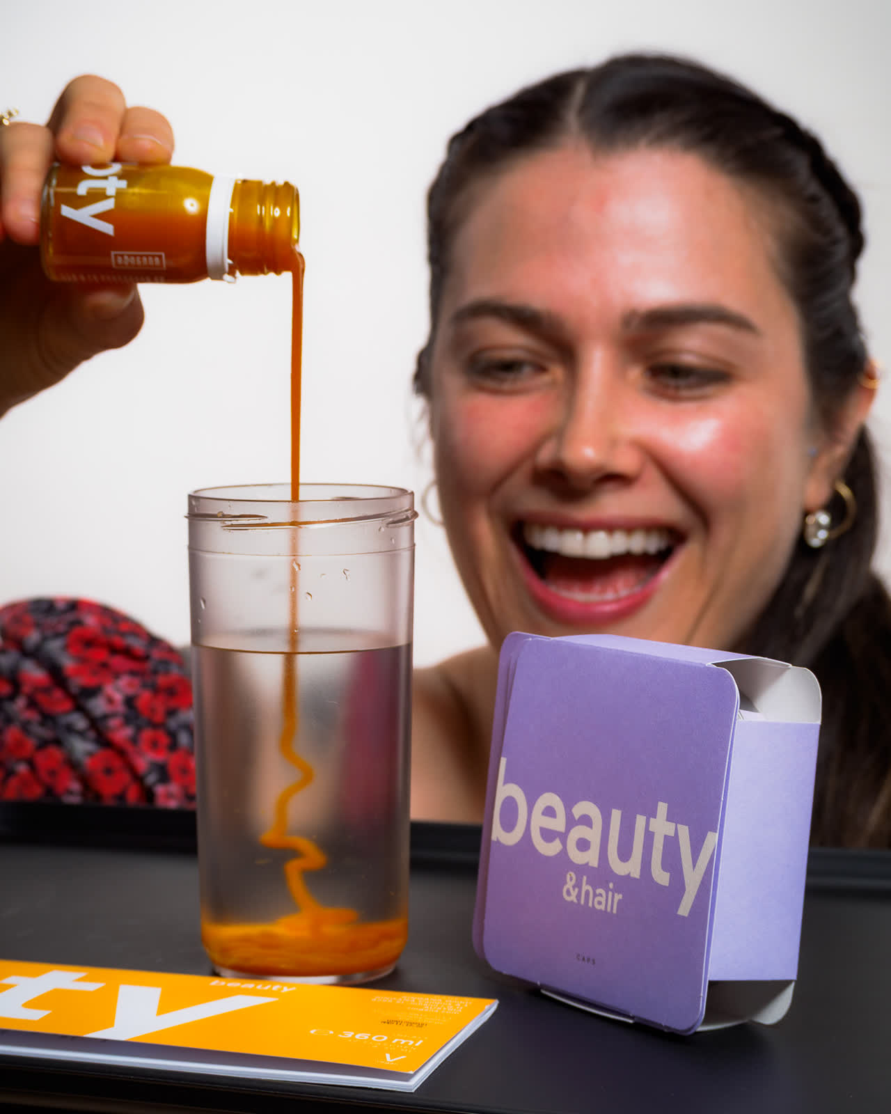 Fotografía de producto de una marca de suplementos de belleza con modelo sonriendo