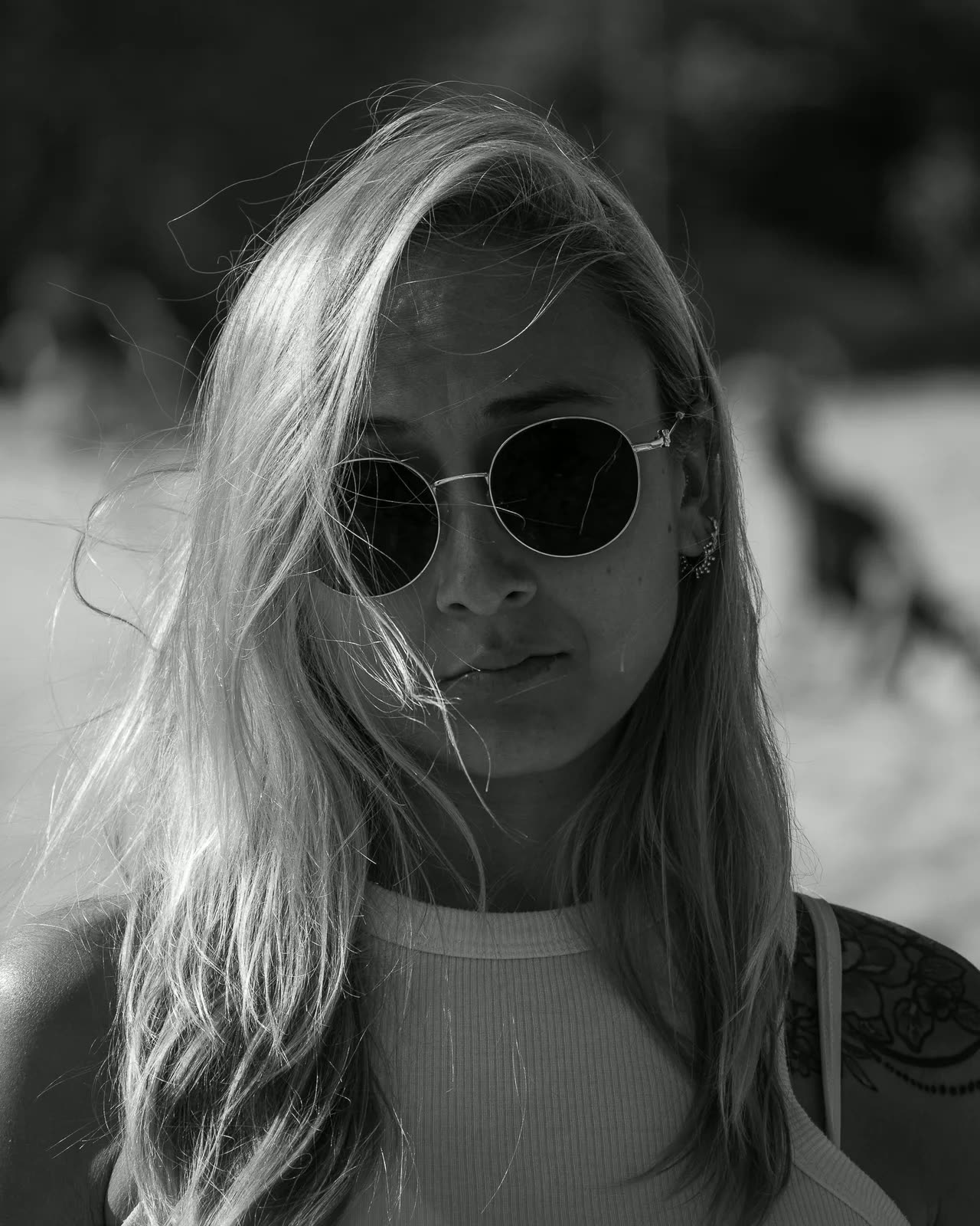 Retrato en blanco y negro de una mujer rubia con gafas de sol redondas